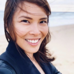 Image of a smiling woman by the beach
