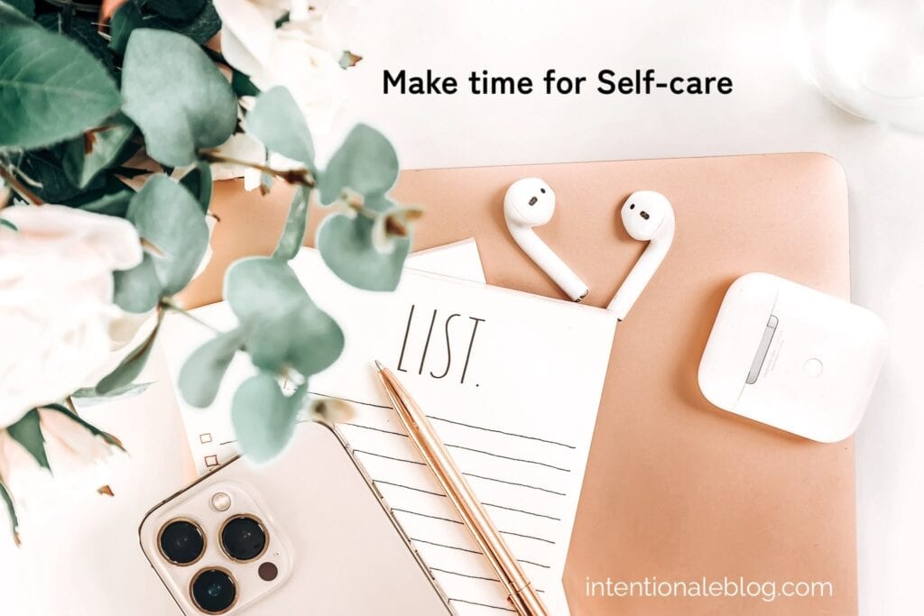 image of a green plan on the upper left, a set of air pod and a case, a pen a beige notebook and a rosegold iphone