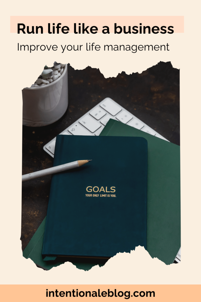 Image of a green notebook, and a white pen on top of a computer white keyboard 