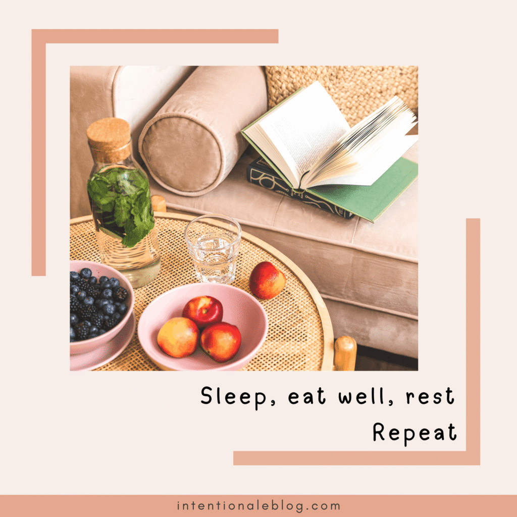 A cozy scene with a sofa, an open book, a glass water bottle, a glass of water, and bowls of blueberries and peaches on a round woven table—perfect inspiration for how to get your life on track. Text reads: Sleep, eat well, rest, Repeat.